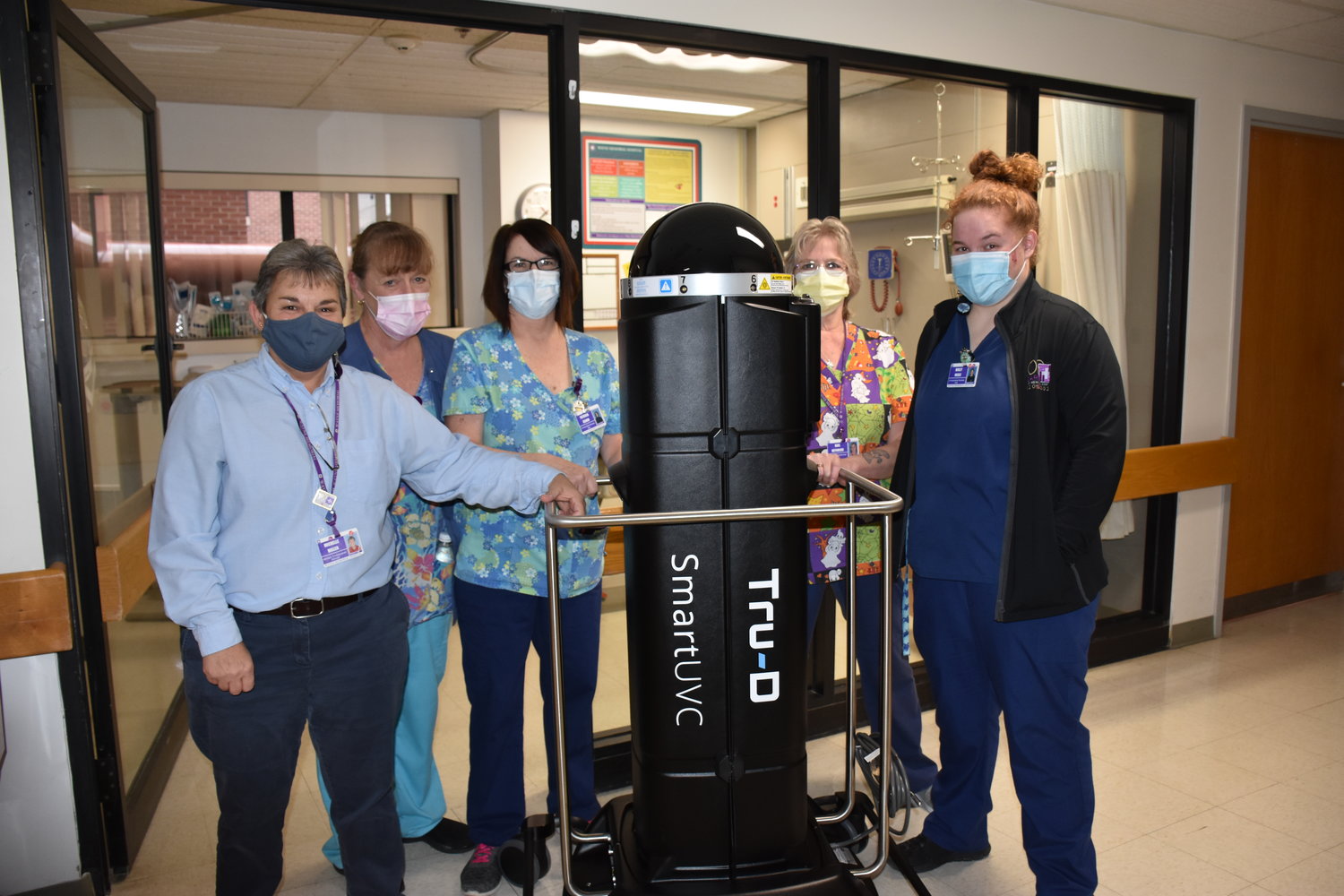 Environmental Services staff Michelle Miller, left, Mary Moser, Patricia Reahm, Gail Reynolds and Molly Nagle with Tru-D Smart UVC robot in the Intensive Care Unit.